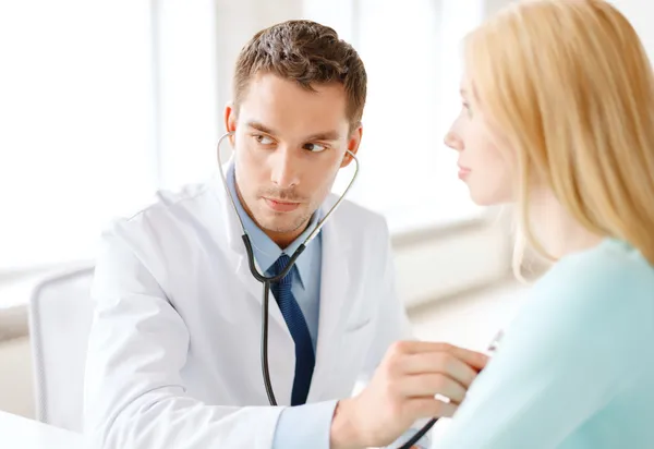 Médico con estetoscopio que escucha al paciente — Foto de Stock