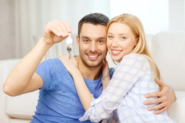 Smiling couple holding keys at home — Stock Photo, Image