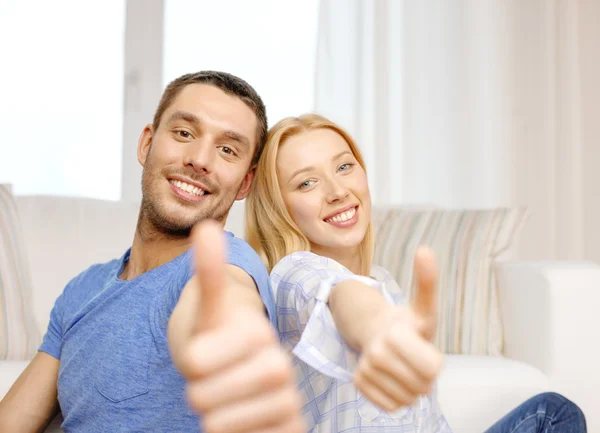 Sorrindo casal feliz em casa mostrando polegares para cima — Fotografia de Stock