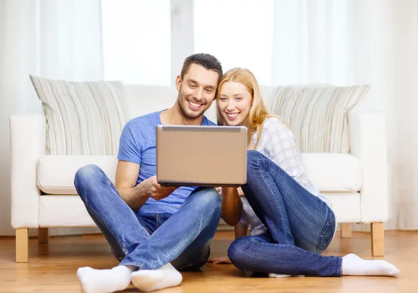 Sonriente feliz pareja con portátil en casa —  Fotos de Stock