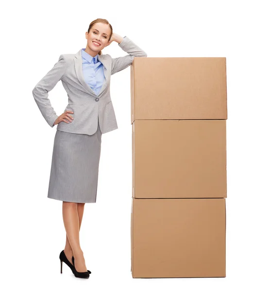 Улыбающаяся деловая женщина с картонными коробками — стоковое фото