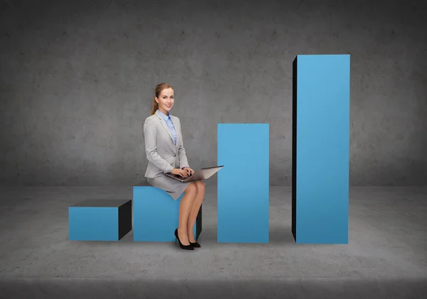 Smiling woman sitting on growing chart with laptop — Stock Photo, Image