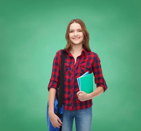 Lächelnde Studentin mit Tasche und Notizbüchern — Stockfoto