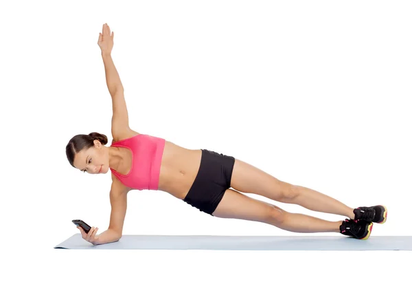 Asiático mulher esportiva com smartphone fazendo exercício — Fotografia de Stock