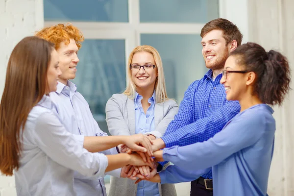 Team mit übereinander hängenden Händen im Amt — Stockfoto