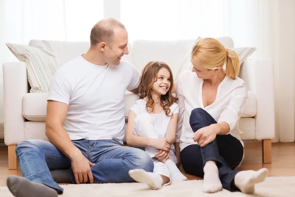 Parents and little girl sitting on floor at home — Stock Photo, Image