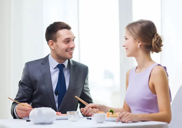 Couple souriant mangeant des sushis au restaurant — Photo