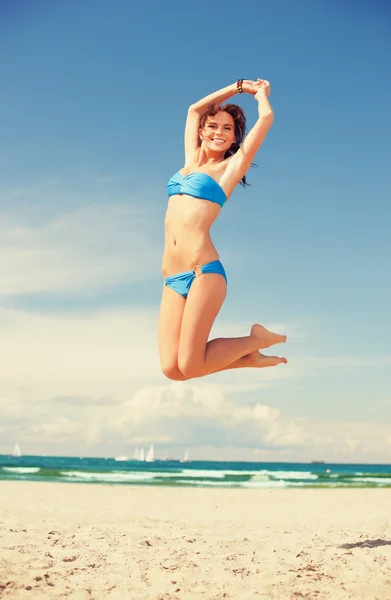 Feliz mujer saltando en la playa — Foto de Stock