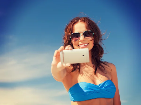 Mujer feliz con teléfono en la playa Imagen de archivo