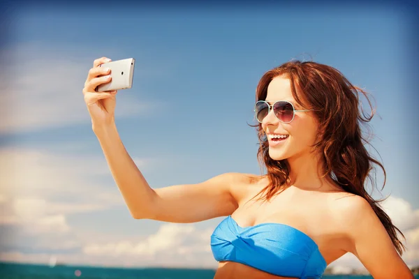 Счастливая женщина с телефоном на пляже — стоковое фото
