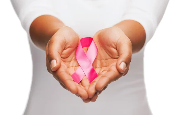 Mãos segurando fita de consciência de câncer de mama rosa — Fotografia de Stock