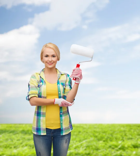 Smiling woman in gloves with paint roller — Stock Photo, Image