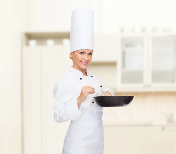 Chef feminino sorridente com panela e colher — Fotografia de Stock