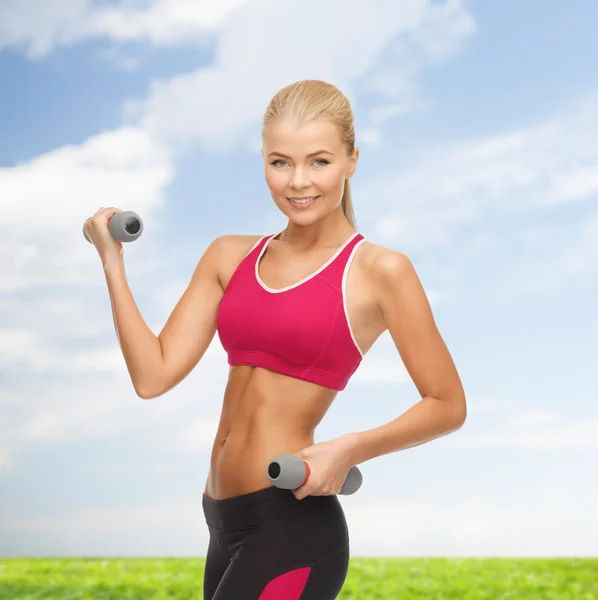 Jovem mulher esportiva com halteres leves — Fotografia de Stock