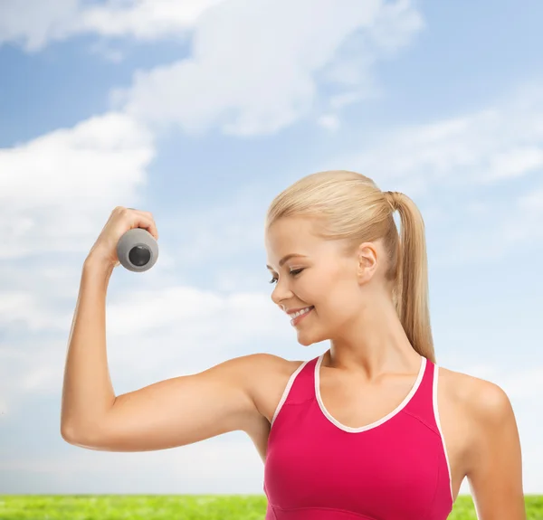 Jonge, sportieve vrouw met lichte dumbbell — Stockfoto