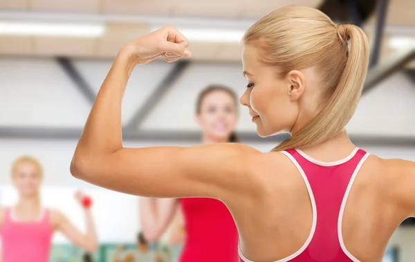 Sportliche Frau zeigt ihren Bizeps — Stockfoto