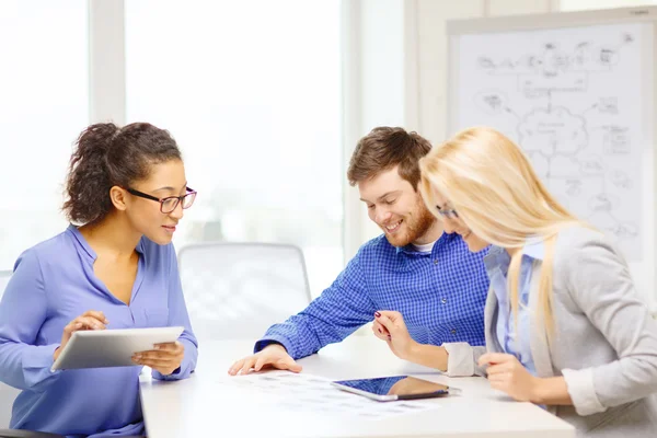 Team sorridente con pc da tavolo e carte funzionanti — Foto Stock