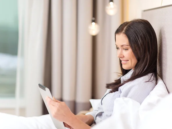 Gelukkig zakenvrouw met tablet pc in een hotelkamer — Stockfoto