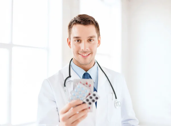 Mosolygó férfi orvos Pills kórházbanuśmiechnięty mężczyzna lekarz z pigułki w szpitalu — Zdjęcie stockowe