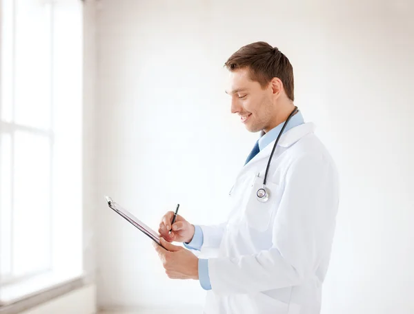Usmívající se muž doktor s stetoskop a schránky — Stock fotografie