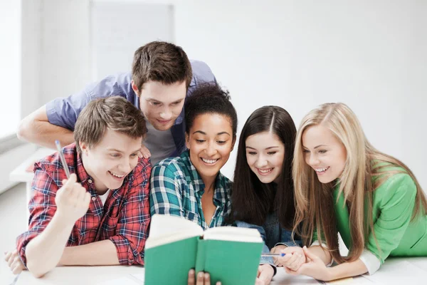 Estudiantes leyendo libro en la escuela — Foto de Stock