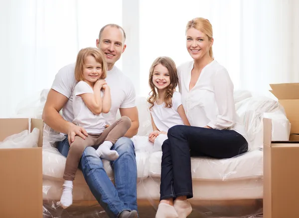 Smiling parents and two little girls at new home Royalty Free Stock Photos