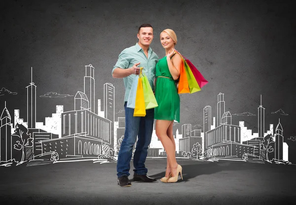 Lachende paar met shopping tassen — Stockfoto