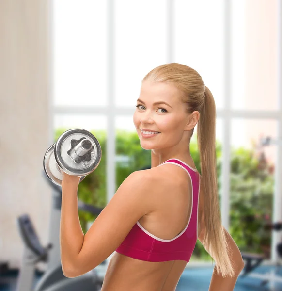 Smiling woman with heavy steel dumbbell — Stock Photo, Image