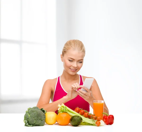 Mujer con verduras apuntando al smartphone —  Fotos de Stock