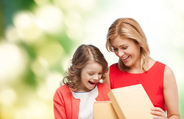 Sorridente madre e figlia apertura confezione regalo — Foto Stock