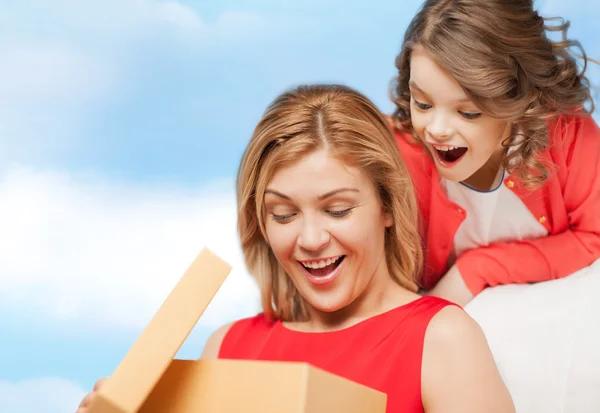 Smiling mother and daughter with gift box — Stock Photo, Image