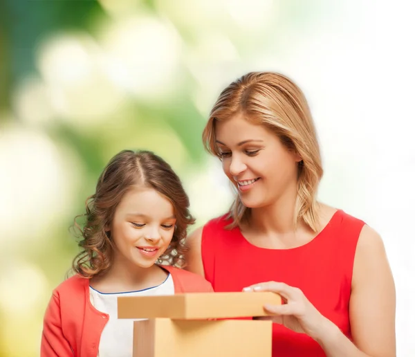 Gülümseyen anne ve kızı hediye kutusu açma — Stok fotoğraf