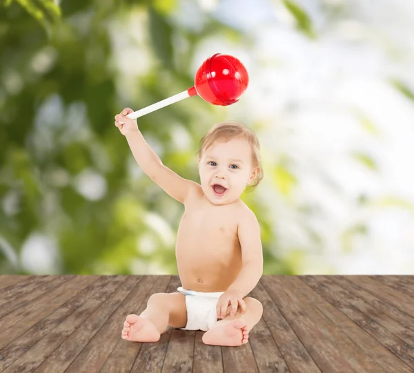 Cute little boy playing with big lollipop — Stock Photo, Image