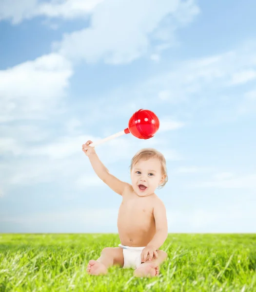 Süßer kleiner Junge spielt mit großem Lutscher — Stockfoto