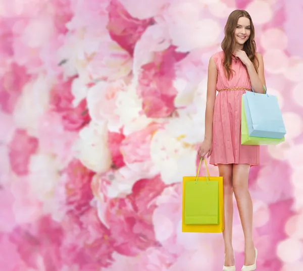 Lächelnde Frau im Kleid mit vielen Einkaufstüten — Stockfoto