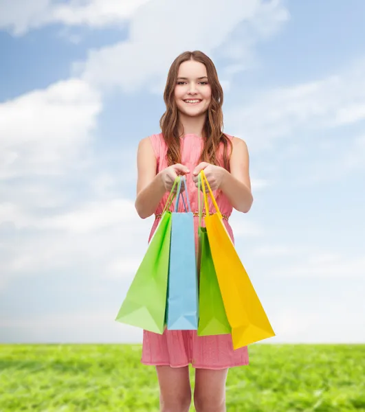 Mulher sorridente em vestido com muitos sacos de compras — Fotografia de Stock