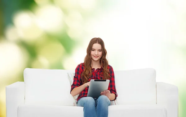 Nastoletnia dziewczyna siedzi na kanapie z komputera typu tablet — Zdjęcie stockowe