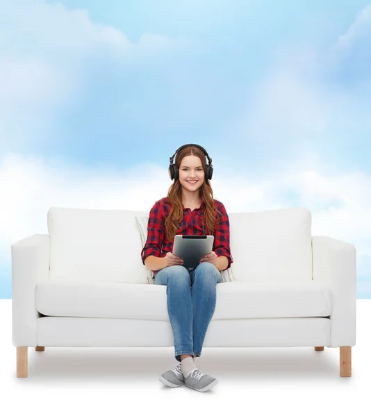 Chica sentada en el sofá con auriculares y tablet PC — Foto de Stock