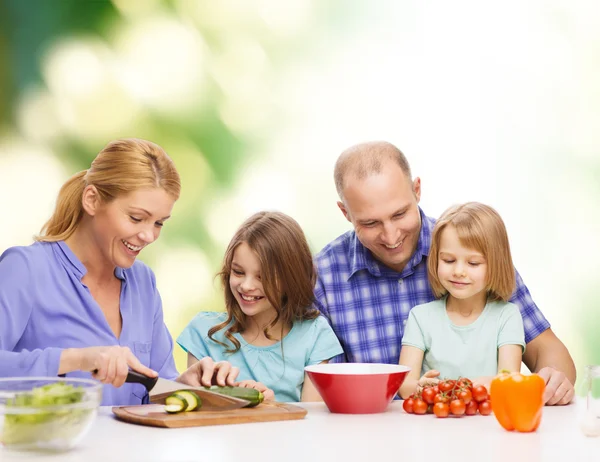 Familia feliz con dos niños haciendo la cena en casa — Foto de Stock