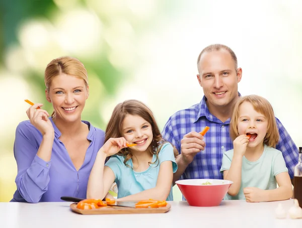 Glückliche Familie mit zwei Kindern beim Essen zu Hause — Stockfoto