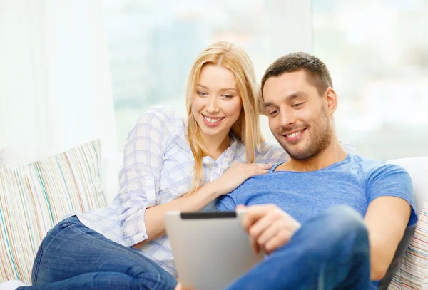 Sorrindo casal feliz com tablet pc em casa — Fotografia de Stock