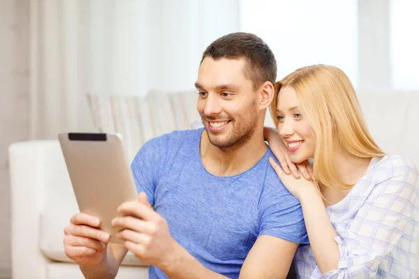 Χαμογελώντας ευτυχισμένο ζευγάρι με tablet pc στο σπίτι — Φωτογραφία Αρχείου
