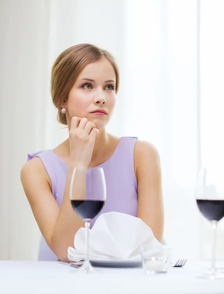 Verärgerte Frau mit Glas Wein beim Warten auf Date — Stockfoto