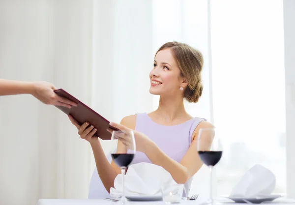 Mujer sonriente dando menú al camarero en el restaurante — Foto de Stock