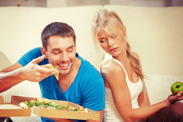 Casal comer comida diferente — Fotografia de Stock