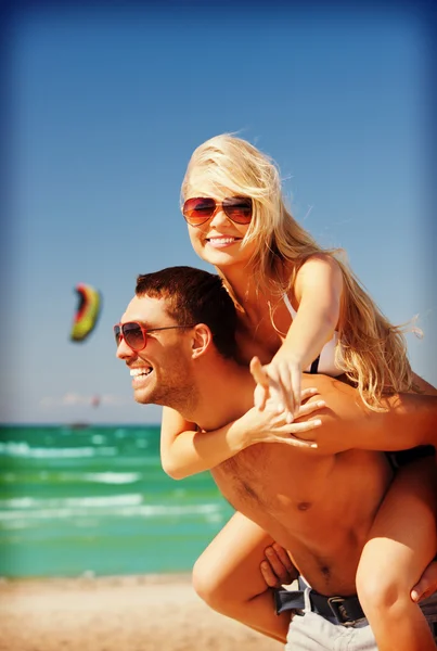 Casal feliz em óculos de sol na praia — Fotografia de Stock