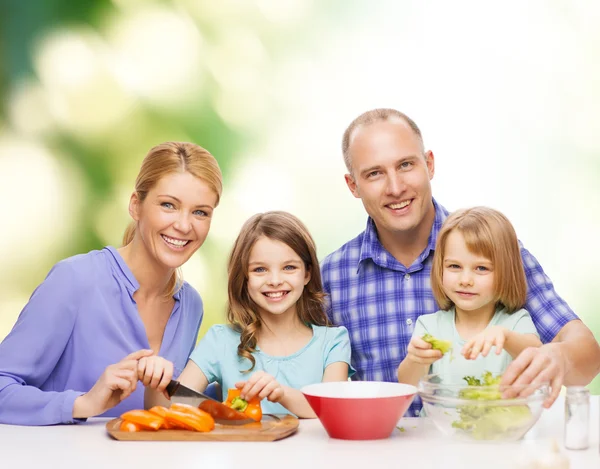 Famiglia felice con due bambini che preparano la cena a casa Immagini Stock Royalty Free