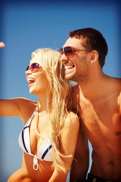 Happy couple in sunglasses on the beach Stock Picture