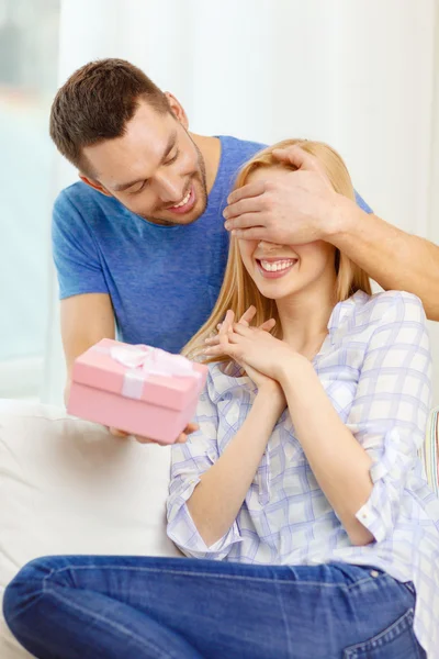 Smiling man surprises his girlfriend with present — Stock Photo, Image