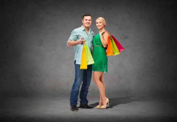 Usmívající se pár s nákupní tašky — Stock fotografie